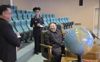 24日に国家航空宇宙技術総局平壌総合管制所を訪れ、笑顔を見せる北朝鮮の金正恩総書記（右）＝朝鮮中央通信・共同
