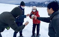 スノーシューを履いて雪のある水田に向かい、熱かんを飲む体験もできる（テスト開催の様子）