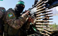 イスラエルとハマスの衝突が中東全域に拡大するリスクがある（７月１９日、ガザ地区の軍事パレードで銃を構えるハマス戦闘員）＝ロイター