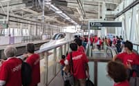 新大村駅（長崎県大村市）で新幹線を待つ人々。多くが赤いTシャツを着ていた

