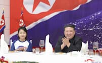 軍事偵察衛星の打ち上げ成功を祝う宴会に、娘（左）と出席した北朝鮮の金正恩朝鮮労働党総書記（11月23日）＝朝鮮中央通信・共同