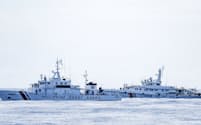 南シナ海・アユンギン礁に向かう途中、中国海警局の艦船（右奥）に追尾されるフィリピン沿岸警備隊の巡視船（11月）＝共同