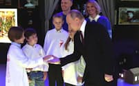 ロシアのプーチン大統領㊨は4日、モスクワ市内で開催中の国際展示フォーラム「ロシア」を訪れ、子どもたちと交流し、大家族を称賛した＝AP