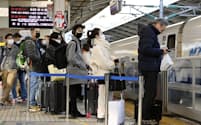 年末年始の国内旅行者数はコロナ禍前の水準に近づきそうだ（帰省ラッシュで混雑するJR東京駅の新幹線ホーム、22年12月29日）
