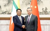中国の王毅外相㊨と握手するミャンマーのタンスエ外相（6日、北京）＝中国外務省ホームページから