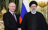 ７日、モスクワでの首脳会談で握手するロシアのプーチン大統領㊧とイランのライシ大統領＝ロイター