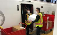 博多駅のホームで荷物を九州新幹線から降ろすJR九州グループの担当者ら(福岡市)