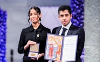 モハンマディさんに代わってノーベル平和賞授賞式に出席した息子アリ・ラフマニさん㊨と娘キアナさん（10日、オスロ）＝NTB/Javad Parsa・ロイター