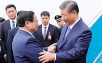 習近平国家主席（右）は12日、ベトナムの首都ハノイに到着した。チン首相が出迎えた＝国営ベトナム通信