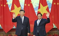 手を振る中国の習近平国家主席とベトナムのチン首相（13日、ハノイ）＝AP