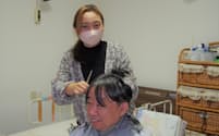 高橋さん㊤は客の笹川さんと世間話をしながら、手際よく髪をカットする（新潟県加茂市）