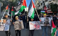 パレスチナ自治区のヨルダン川西岸で、ガザへの連帯を示すデモに参加する人々（11日、ラマラ）＝ロイター