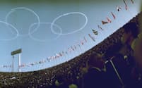 1964年東京五輪の開会式では、国立競技場の空に自衛隊機（ブルーインパルス）の描いた五輪マークが浮かんだ