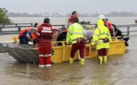 18日、オーストラリア・クイーンズランド州で起きた大雨でボートで避難する人々＝クイーンズランド州消防災害局提供・共同