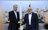 イラン外相と握手するハマス指導者のハニヤ氏㊨（20日、ドーハ）=AP