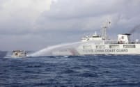 南シナ海のアユンギン礁付近でフィリピン当局の船に向かって放水砲を発射する中国海警局の船（10日）＝AP・共同