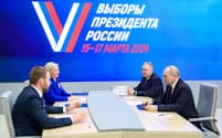 ロシアのプーチン大統領（右）は18日、モスクワの中央選管を訪れて大統領選立候補に必要な書類を提出した＝タス