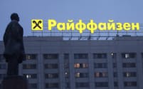 ロシアの事業縮小を模索する（モスクワ中心部のレーニン像前のライファイゼンの広告看板）＝ロイター