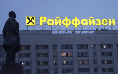 ロシアの事業縮小を模索する（モスクワ中心部のレーニン像前のライファイゼンの広告看板）=ロイター