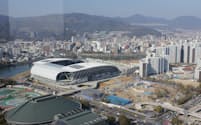 広島の新サッカースタジアム「エディオンピースウイング広島」。隣接地では8月開業を目指して商業施設などの工事が続く（広島市）