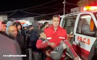 イスラエル軍のガザへの砲撃による負傷者を運ぶ救急隊員（パレスチナ赤新月社が30日に公開した動画から）＝ロイター