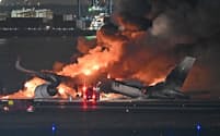 羽田空港の滑走路で炎上する日本航空機(2日午後、羽田空港)