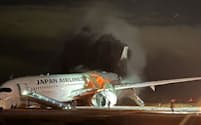羽田空港の滑走路で炎上する日航516便＝2日午後6時ごろ（乗客提供）