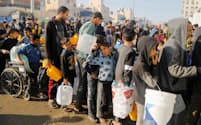 4日、ガザ南部ラファで給水の列に並ぶ人々。清潔な水の入手が困難になっている＝ロイター