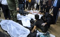 ３日、イラン南東部ケルマンで爆発の犠牲になった市民の遺体のそばにたたずむ遺族＝ＡＰ