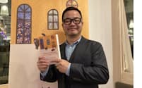 フランス語に翻訳された自著を手にする小説家・脚本家・演出家の川口俊和さん（2023年10月、パリ）