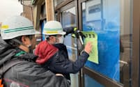 能登半島地震で被害を受けた住宅の危険度を判定する富山県職員（7日、氷見市）