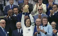 1974年7月、サッカーW杯西ドイツ大会で優勝し、トロフィーを掲げるベッケンバウアー（中央）＝AP