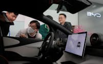 中国自動車メーカーの世界シェアは2030年までに33%へと倍増する可能性あるという（上海のショールームでBYDのEVを見る若者）=ロイター