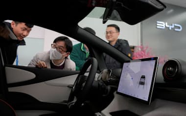 中国自動車メーカーの世界シェアは2030年までに33%へと倍増する可能性あるという（上海のショールームでBYDのEVを見る若者）=ロイター