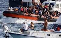 欧州への移住希望者を乗せたイタリア沿岸警備隊の船。同国のメローニ政権は人道支援団体が地中海で移民を救出するのを妨害する一方、EU域外出身の移民向けに50万件近い就労許可証を発行した＝ロイター