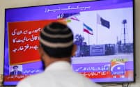 パキスタン外務省がイラン領内への攻撃を発表した後、ニュースを見る人（18日、パキスタン・カラチ）＝ロイター