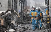 地震直後の火災で全域が焼失した「輪島朝市」付近で活動する警察官ら＝13日午前、石川県輪島市