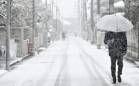 雪が積もった道を歩く人たち（10日、東京都練馬区）