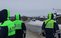 ロシア西部のベルゴロド州の軍輸送機の墜落現場周辺では警察官が道路を封鎖した(24日)＝ロイター