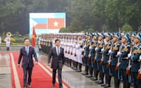 30日、フィリピンのマルコス大統領（写真中央）と並んで歩くベトナムのトゥオン国家主席（同左）＝フィリピン大統領府提供