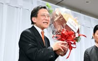京都市長選で当選を決め、花束を手に笑顔を見せる松井孝治氏（4日、京都市中京区）