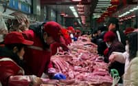 豚肉など食品の値下がりが目立った（2日、北京にある卸売市場の豚肉販売コーナー）＝ロイター