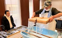 御影倶楽部では障害のある利用者が分業で手すき紙の製品を作る（２月、神戸市）