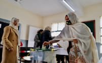 男女別室の投票所で一票を投じる女性（８日、イスラマバード）