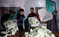 パキスタン総選挙の投票終了後に、開票作業を始めた投票所のスタッフ（８日、ラホール）＝ロイター