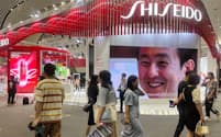 FILE PHOTO: People walk past a booth of Japanese cosmetic brand Shiseido at the third China International Consumer Products Expo, in Haikou, Hainan province, China April 11, 2023. REUTERS/Casey Hall/File Photo