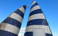 
東京湾アクアラインの「風の塔」の上空を飛ぶ羽田空港発着の航空機