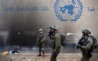 ２月８日、パレスチナ自治区ガザにあるUNRWA本部前で軍事作戦を展開するイスラエル兵＝ロイター