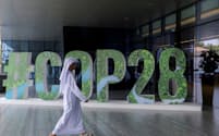 FILE PHOTO: A person walks past a "#COP28" sign during The Changemaker Majlis, a one-day CEO-level thought leadership workshop focused on climate action, in Abu Dhabi, United Arab Emirates, October 1, 2023. REUTERS/Amr Alfiky/File Photo