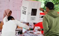インドネシア大統領選で開票する投票所のスタッフら（14日、ジャカルタ）=小林健撮影